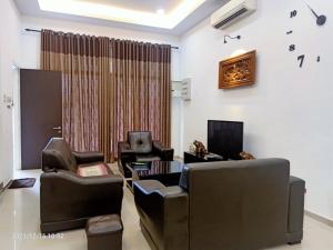 a living room with leather chairs and a television at Kuala Selangor Botanic 4R3B Homestay 15pax in Kuala Selangor
