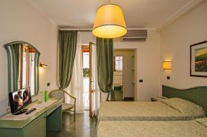 ein Hotelzimmer mit 2 Betten und einem Spiegel in der Unterkunft Hotel Kyrton in Forte dei Marmi