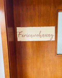 a sign on a wooden door with the word terminology at Ferienwohnung Emma an der Romantischen Straße in Weikersheim