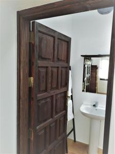 a bathroom with a wooden door and a sink at Casa Mocan in Arrecife