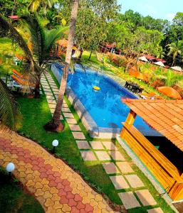 una vista aérea de una piscina con palmeras en Coco Teros Resort, en Mandrem