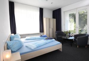 een slaapkamer met een groot bed met blauwe kussens bij Haus Venusberg Jugendbildungsstätte Bonn in Bonn