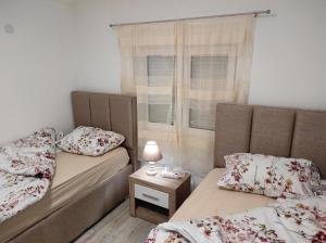 a room with two beds and a table with a lamp at Vila Lake Krupac in Nikšić