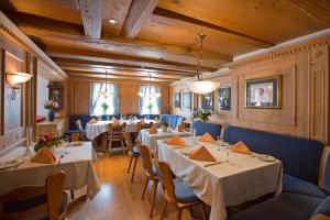 ein Restaurant mit weißen Tischen und blauen Stühlen in der Unterkunft Hotel Post Jungingen in Jungingen