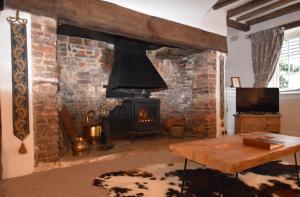 a living room with a fireplace and a stove at Oak House in Rye