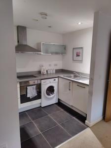 a kitchen with a washing machine and a sink at Cornhill Apartment by Serviced Living Liverpool in Liverpool