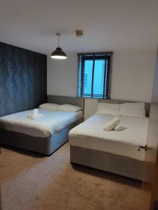 dwa łóżka w pokoju z oknem w obiekcie Cornhill Apartment by Serviced Living Liverpool w Liverpoolu