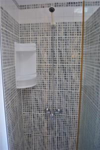 een douche in een badkamer met een betegelde muur bij La Palma Ocean View in Mazo