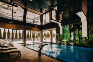 une maison avec une piscine dans une chambre dotée de fenêtres dans l'établissement Pensjonat Jurkowski Wellness & Spa, à Ochotnica Dolna