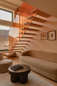 a staircase in a living room with a couch and a table at Warszauer Hotel in Kraków