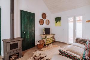 a living room with a fireplace and a green door at Cá Estamos ~ Hortacasa Portugal in Santiago do Cacém