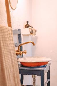 lavabo con grifo de cobre sobre una mesa en Cá Estamos ~ Hortacasa Portugal, en Santiago do Cacém