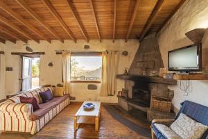 a living room with a couch and a fireplace at Finca La Isa in Tejeda