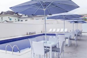 uma mesa e cadeiras com guarda-sóis ao lado de uma piscina em Americas Townhouse Hotel no Rio de Janeiro