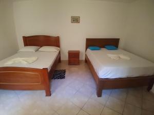 2 camas en una habitación pequeña con baño privado en Pensão Domingas, en São Filipe