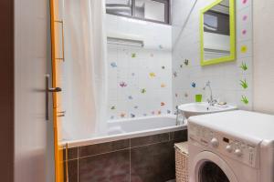 a bathroom with a sink and a washing machine at Superbe appartement spacieux avec parking gratuit in Illzach +5 photos