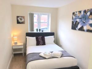 1 dormitorio con 1 cama con 2 toallas en 2 bedroom Large Town Centre Apartment FREE Parking, en Loughborough