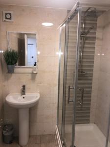 un bagno con lavandino e doccia con porta in vetro di 2 bedroom Large Town Centre Apartment FREE Parking a Loughborough