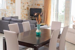 ein Esszimmer mit einem Tisch mit Stühlen und einem Sofa in der Unterkunft Villa Mounda Poseidon, Sea View Villa with pool in Ratzaklíon