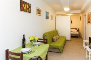 a living room with a table and a green couch at Apartment Edita in Dubrovnik