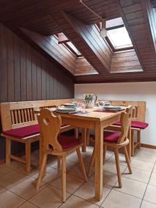 comedor con mesa de madera y sillas en MANSARDA MARMOLADA sui campi da sci, en Alba di Canazei