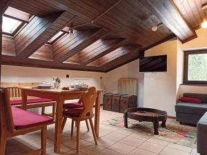 a living room with a table and a couch at MANSARDA MARMOLADA sui campi da sci in Alba di Canazei