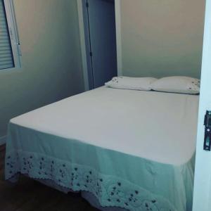 ein weißes Bett mit zwei Kissen darüber in der Unterkunft Praia do Sonho in Palhoça