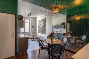 a kitchen and dining room with tables and chairs at LE COURSIVE - Charmant T2 à Villeurbanne in Villeurbanne