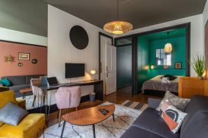 a living room with a couch and a bed at LE COURSIVE - Charmant T2 à Villeurbanne in Villeurbanne