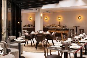 a restaurant with tables and chairs and a piano at Hôtel Moderniste in Paris