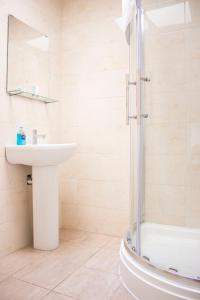 uma casa de banho com um lavatório e um chuveiro em Large Ground Floor Pet Friendly 2 Bedroom Apartment with FREE Parking em Loughborough