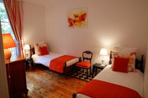 a room with two beds and a chair and a window at Le Gîte du Bas Manoir in Bretteville-sur-Odon