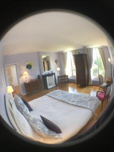 ein Schlafzimmer mit einem großen Bett in einem Zimmer in der Unterkunft Maison de vacances _ Le Bas Manoir in Bretteville-sur-Odon