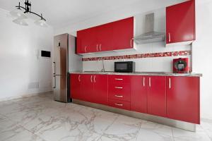 a kitchen with red cabinets and a refrigerator at Casa Auxilia in Araya