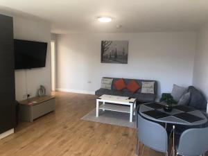 a living room with a couch and a table at Large Ground Floor Pet Friendly 2 Bedroom Apartment with FREE Parking in Loughborough