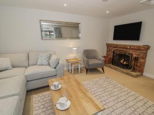 a living room with a couch and a fireplace at 5 Grange Cottages in Southam