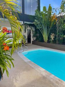 a blue swimming pool in front of a building at Pousada e Restaurante Manah in Propriá