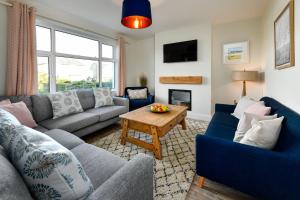 a living room with a couch and a table at Cae Engan in Abersoch