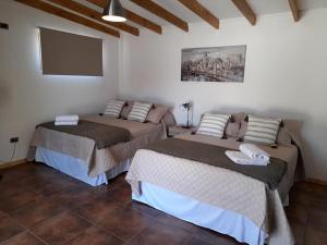 two beds in a room with white walls at Cabañas Stommeln in Ovalle