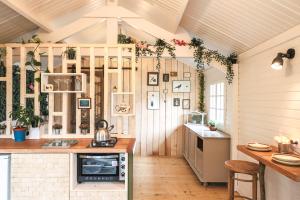 a kitchen in a tiny house with wooden walls at Chalet Nature & Spa in Amayé-sur-Orne