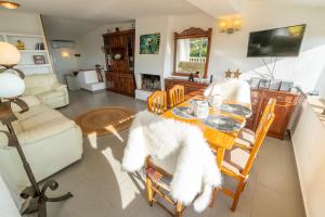 ein Wohnzimmer mit einem Esstisch und weißen Möbeln in der Unterkunft Villa Vista Lux, Piscina privada y zona exterior con vista Mar in Tossa de Mar