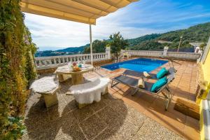 eine Terrasse mit einem Pool, einem Tisch und Stühlen in der Unterkunft Villa Vista Lux, Piscina privada y zona exterior con vista Mar in Tossa de Mar