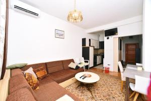 ein Wohnzimmer mit einem Sofa und einem Tisch in der Unterkunft Apartman centar blizina Kastela i Splava in Banja Luka