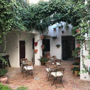 un patio esterno con tavoli, sedie e piante di La Casa de Félix a Villena