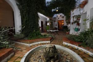 un patio con una fuente y un árbol en La Casa de Félix en Villena