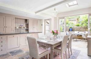 a kitchen with a table with chairs and a dining room at Stanley Cottage in Chipping Campden