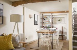 a living room with a dining room table and chairs at Barn End Cottage in Chipping Campden