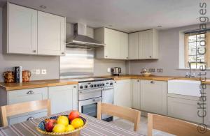 a kitchen with a bowl of fruit on a table at Shenley in Broadwell