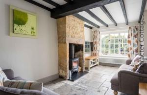 a living room with a fireplace and a couch at Willow Vale in Snowshill