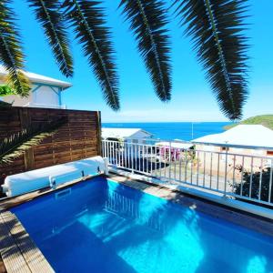 a swimming pool with a view of the ocean at Rose phoenix appartement terrasse et piscine vue mer in Les Anses-dʼArlets